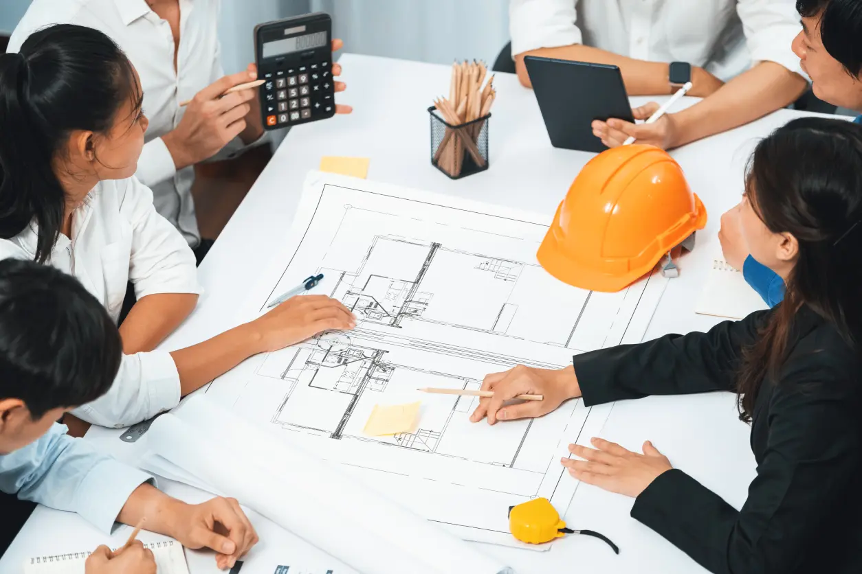 Team discussing architectural plans at a table.