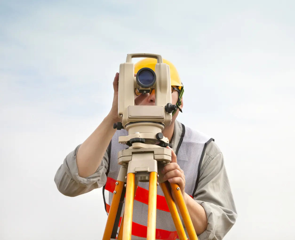 Surveyor using equipment on a construction site.